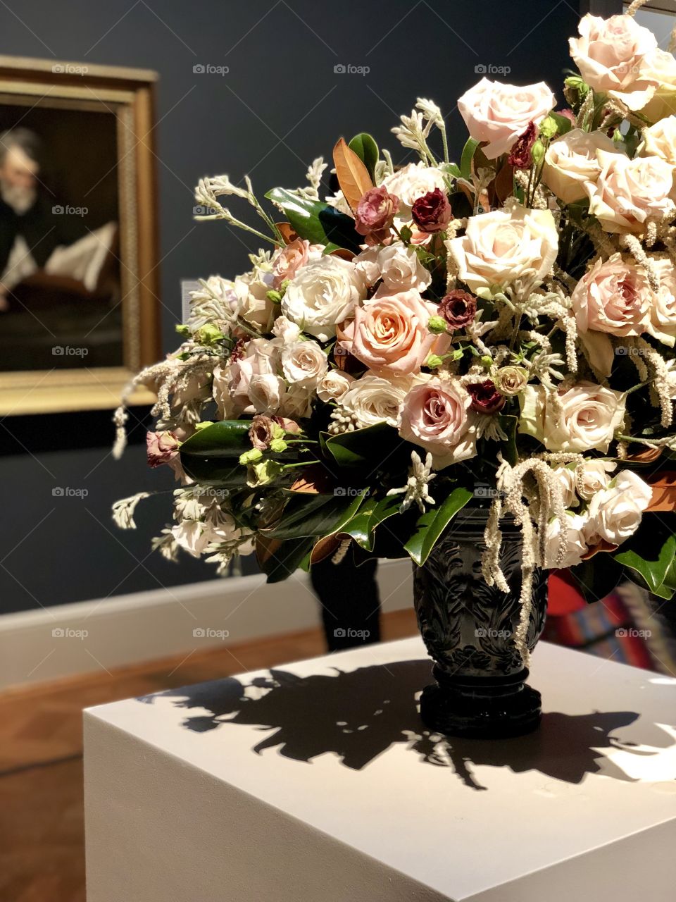 A floral arrangement designed to compliment the painting behind it. 