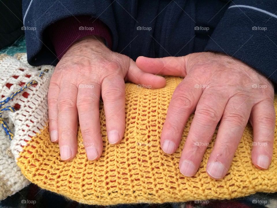 Old man hands on a warm bag