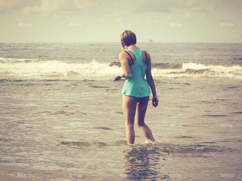 Rear view of a woman standing in sea