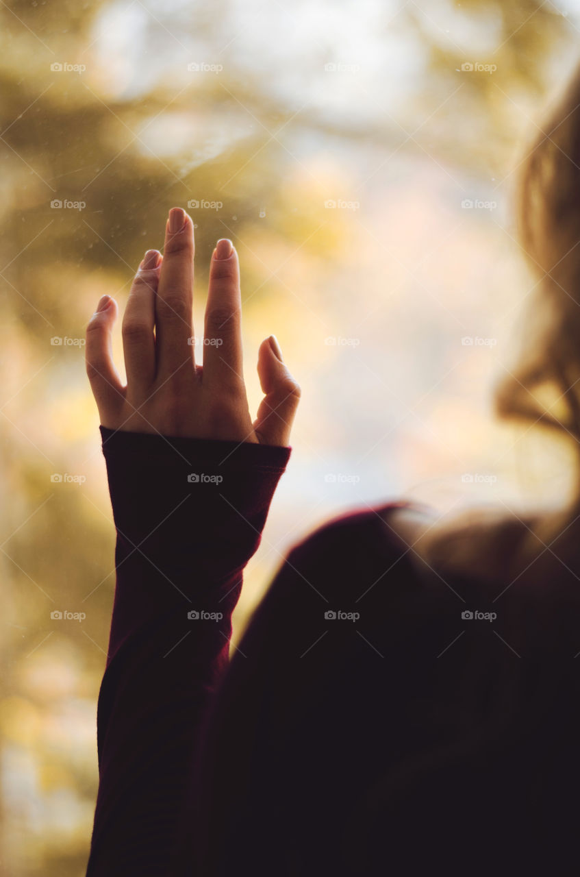 A girl looking through the window. Autumn day. Thinking. Wishing. Waiting.       