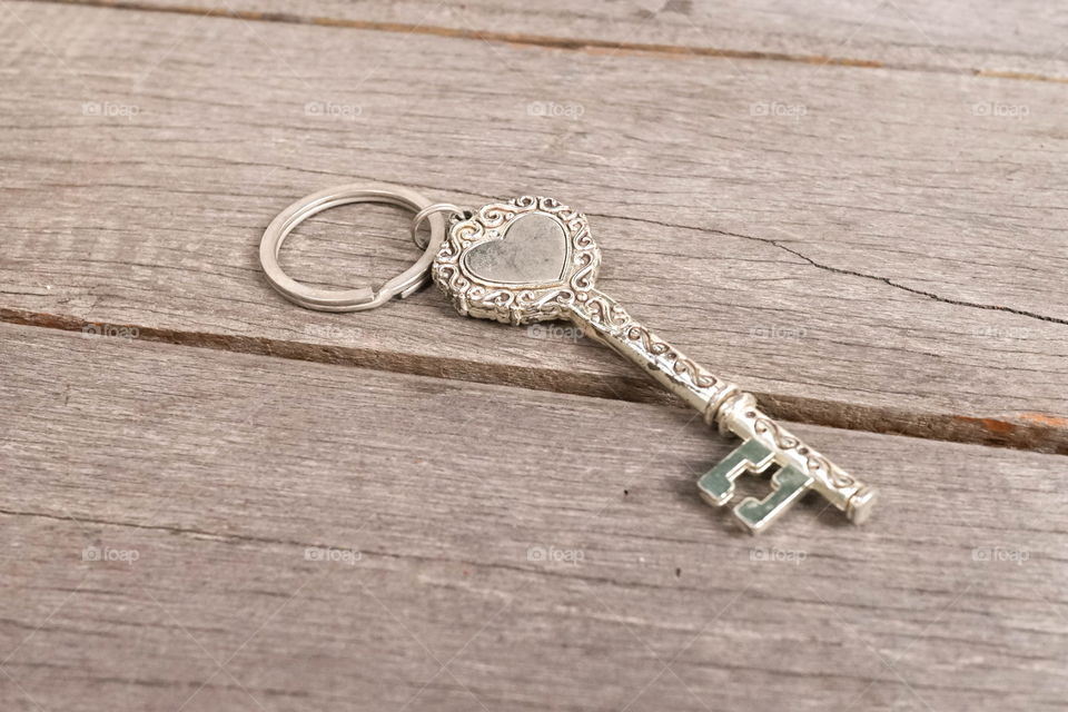 Vintage key. Vintage key with heart shape isolated on the wooden background. Love and mysterious concept