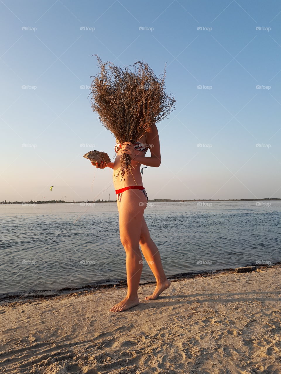 Girl alone walk at the beach with bouquet