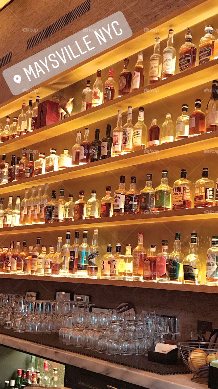 whiskey bottles line the shelves behind the bar in Manhattan