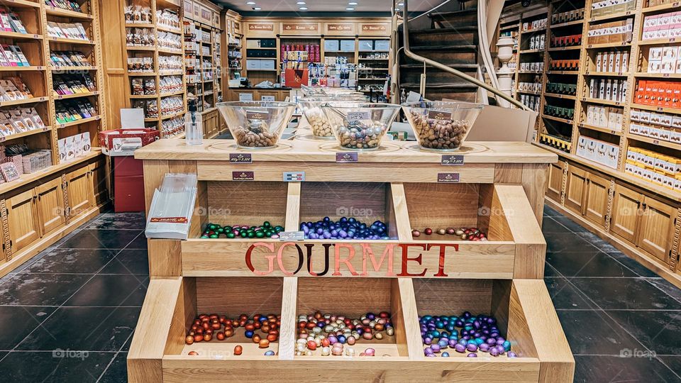 A beautiful view of the interior of a chocolate shop with counters and a variety of gourmet brand sweets in the city of Brussels on the grand place, close-up side view. Belgian chocolate concept.