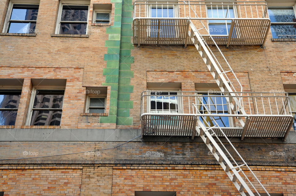 Graphic lines and orange brown and green colored bricks of a city building 