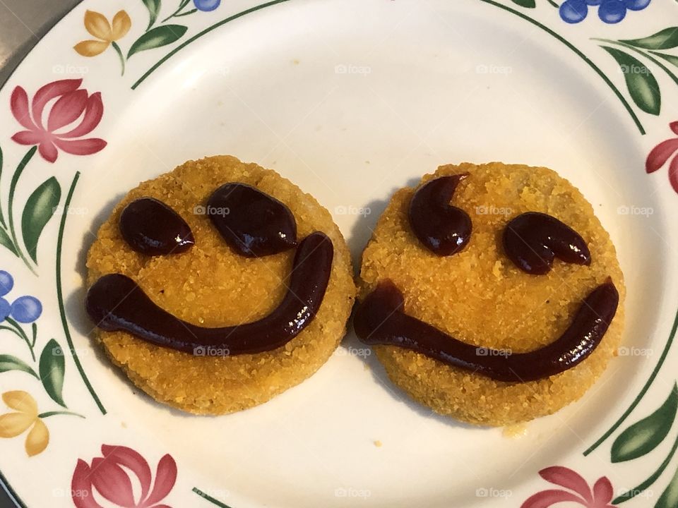 Smiles of barbecue sauce on chicken patties