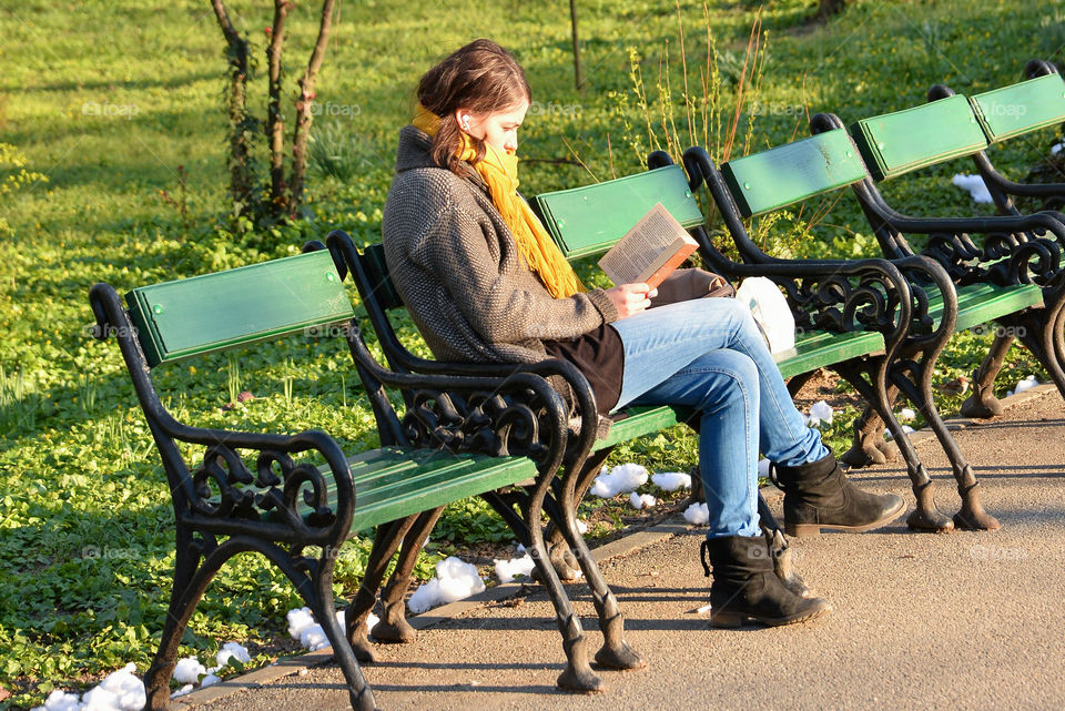 Girl reading a book in park, in the spring