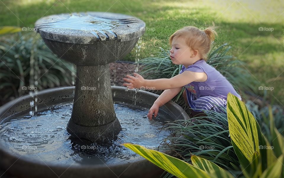 Girl playing near the fountain