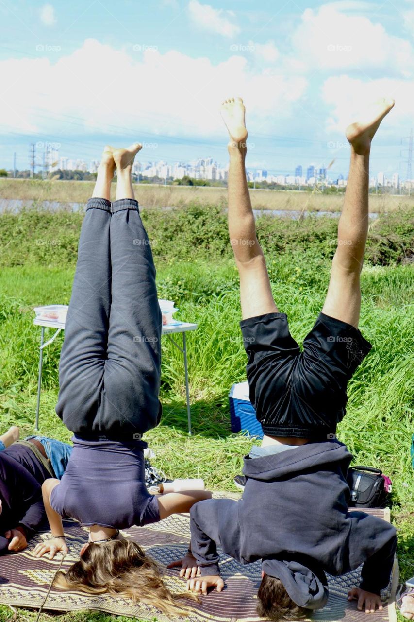 Headstand in a picnic at city park 