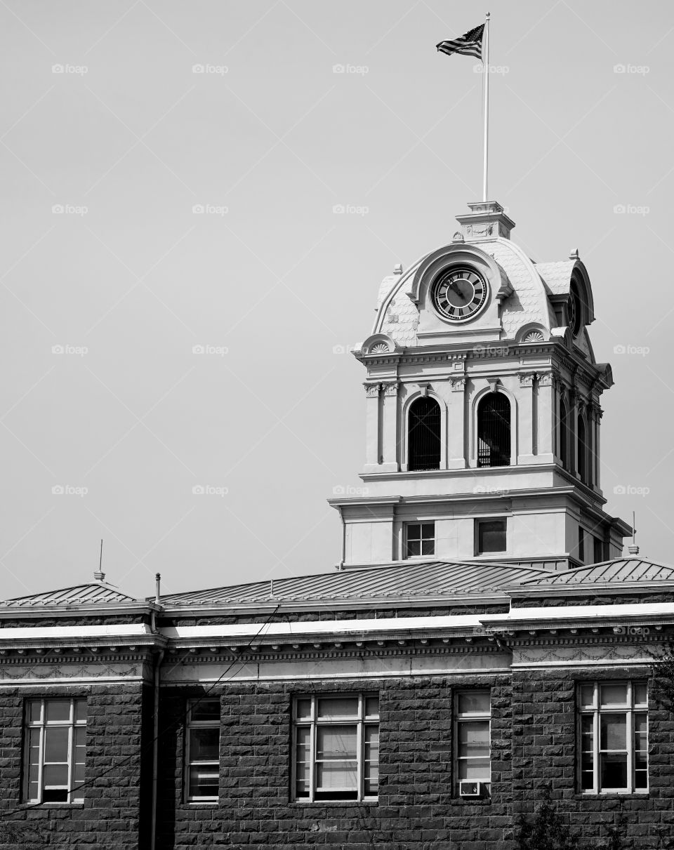 The American Flag flies over a clock tower in Central Oregon.