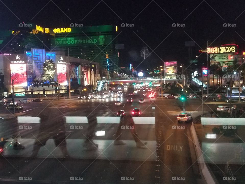 Crosswalk. The reflection of visitors' feet in a crosswalk bridge overshadows the busy Las Vegas street below.