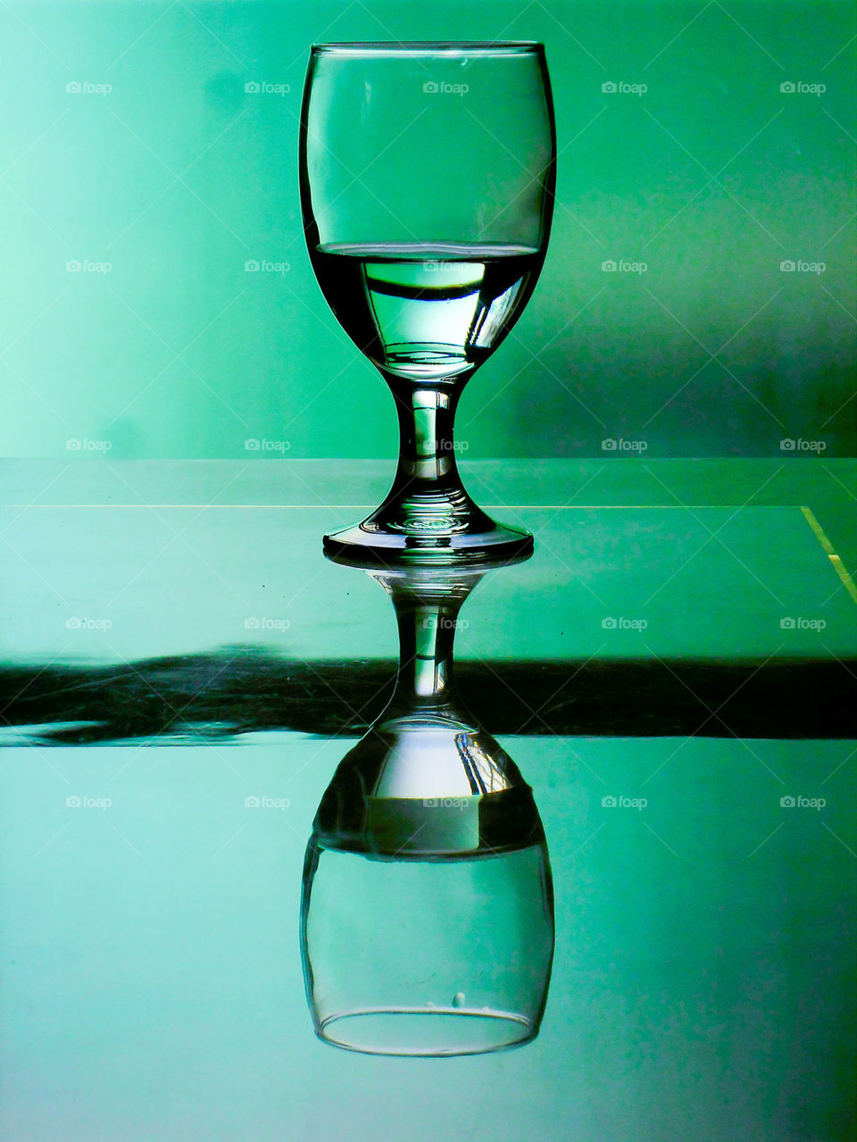 water in a water goblet on a reflective table