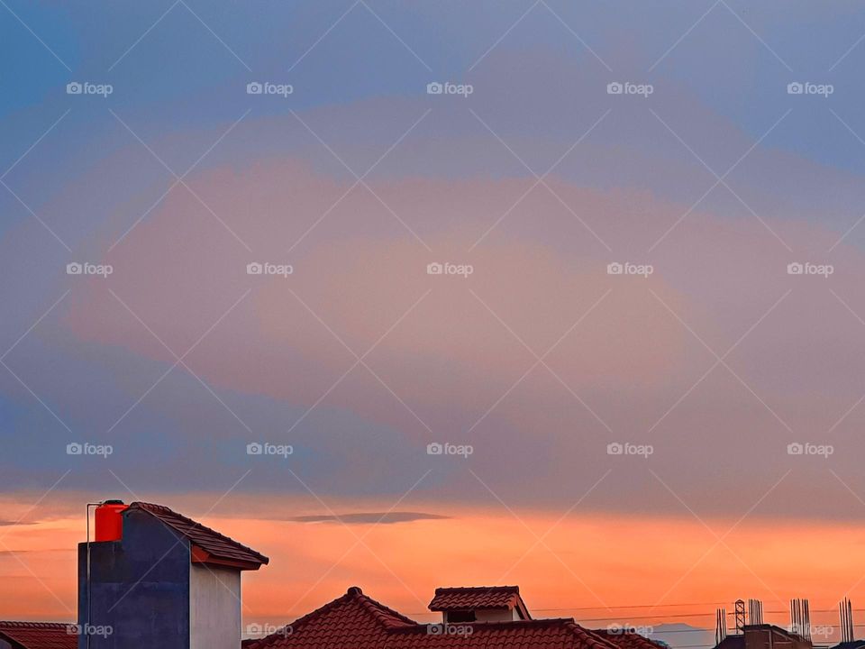 the sky is cloudy in the morning, the view in teh early morning, the sky is covered by clouds and fog, the clouds and red and yellow, the fog covers the view of the sky so that it looks gray,