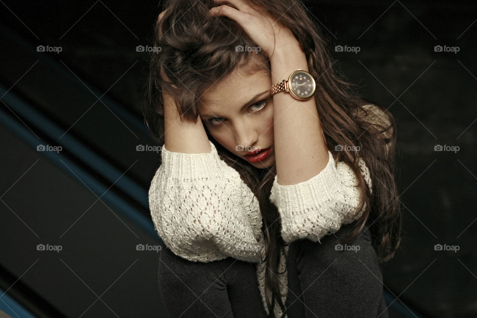 young beautiful girl with watch holding her head with both hands