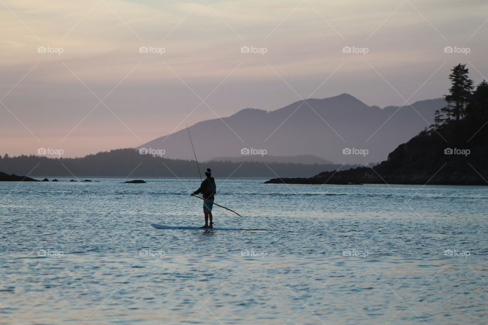 Staying in shape physically & mentally! This paddler is going for a leisurely evening paddle and decided to take a fishing pole to make it even more relaxing. A perfect way to watch the sun set on the West Coast!