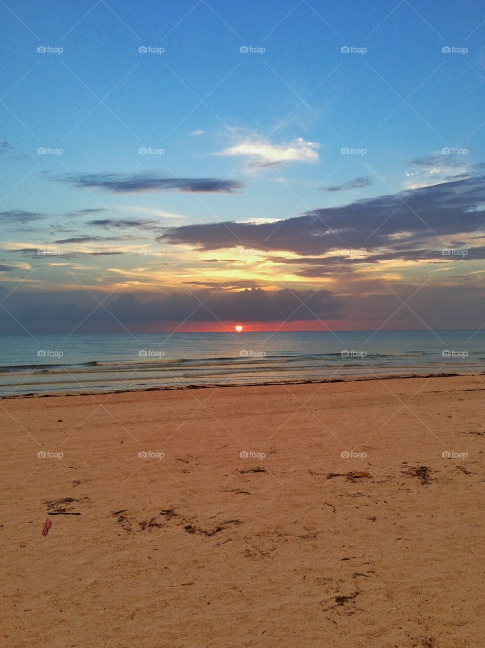 Distant Sunset . The sun setting just below the clouds. 