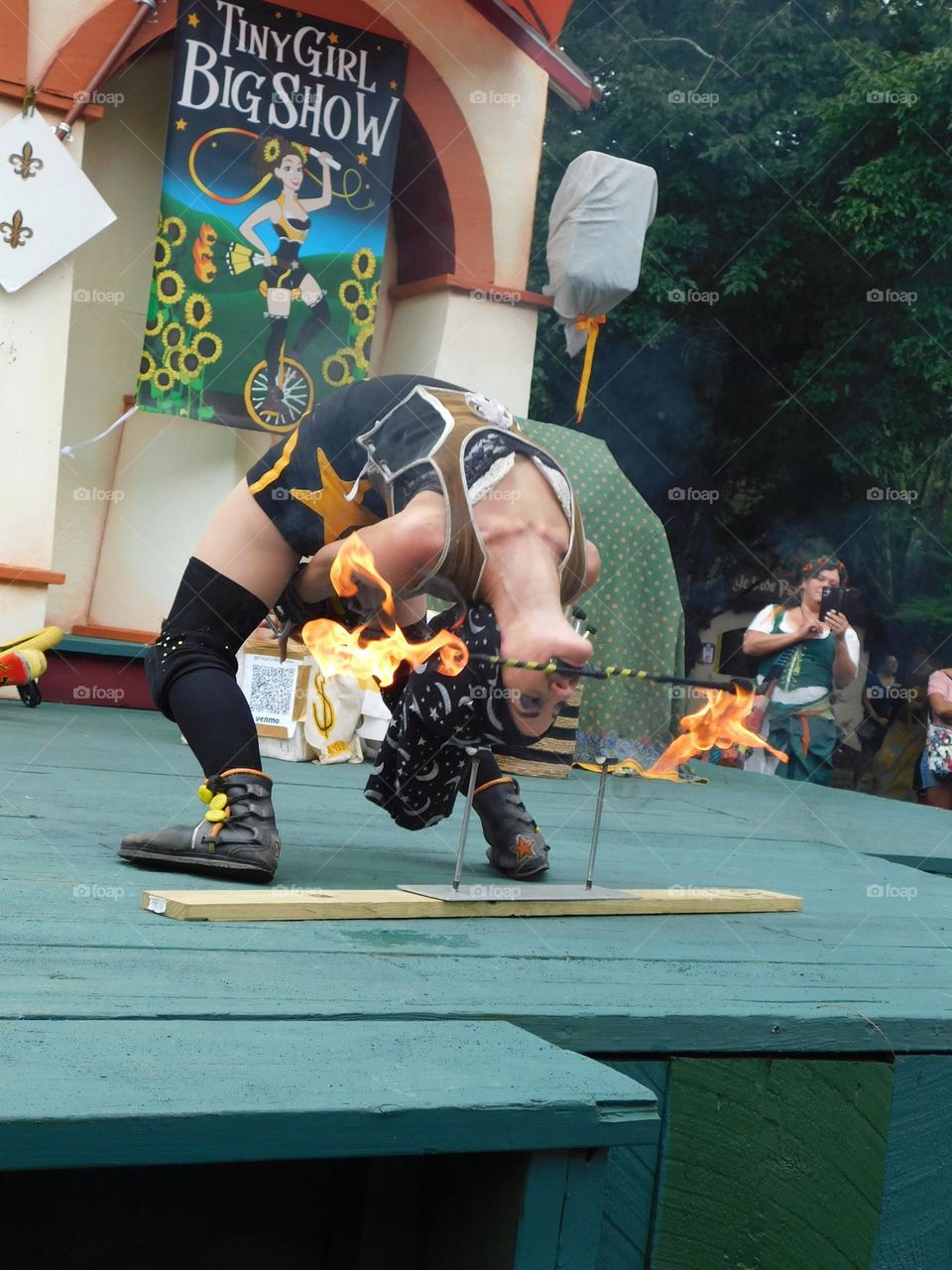 Female contortionist on stage with fire 