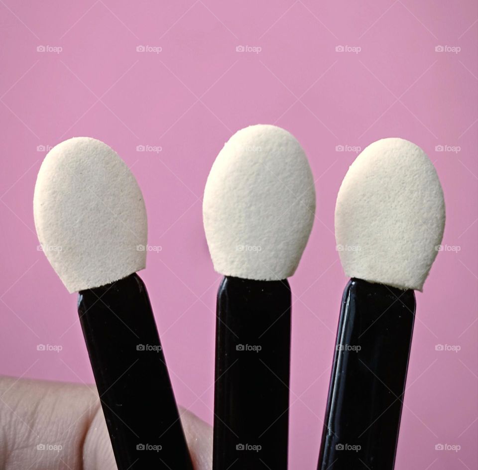 Eye shadow sticks in pink background...