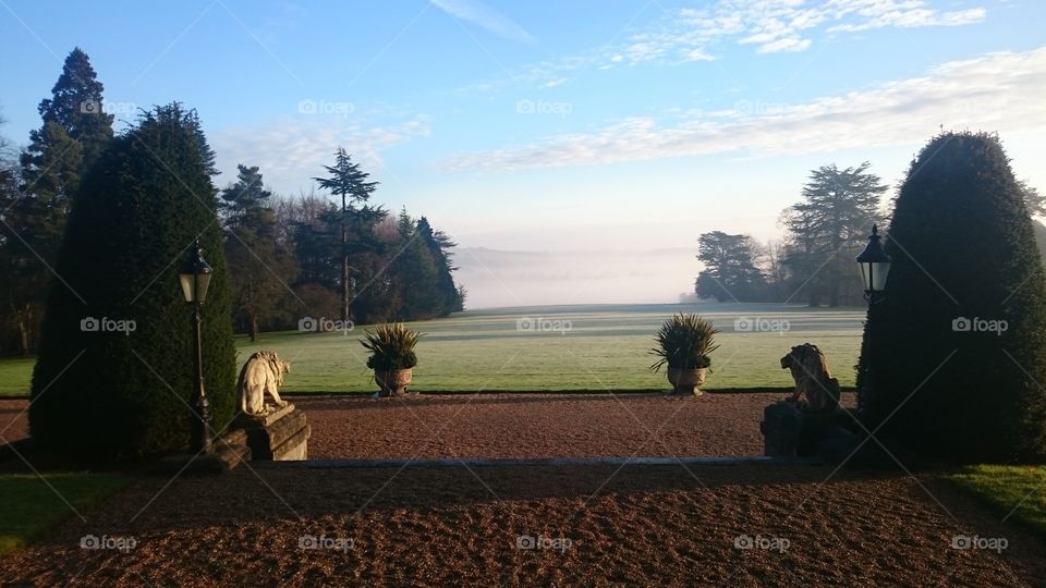 View down the lawn at the back of The Mansion House at the Luton Hoo Hotel, towards the River Lea. Early morning mist obscures the view of the water. Shot from the Wernher Restaurant in Winter.