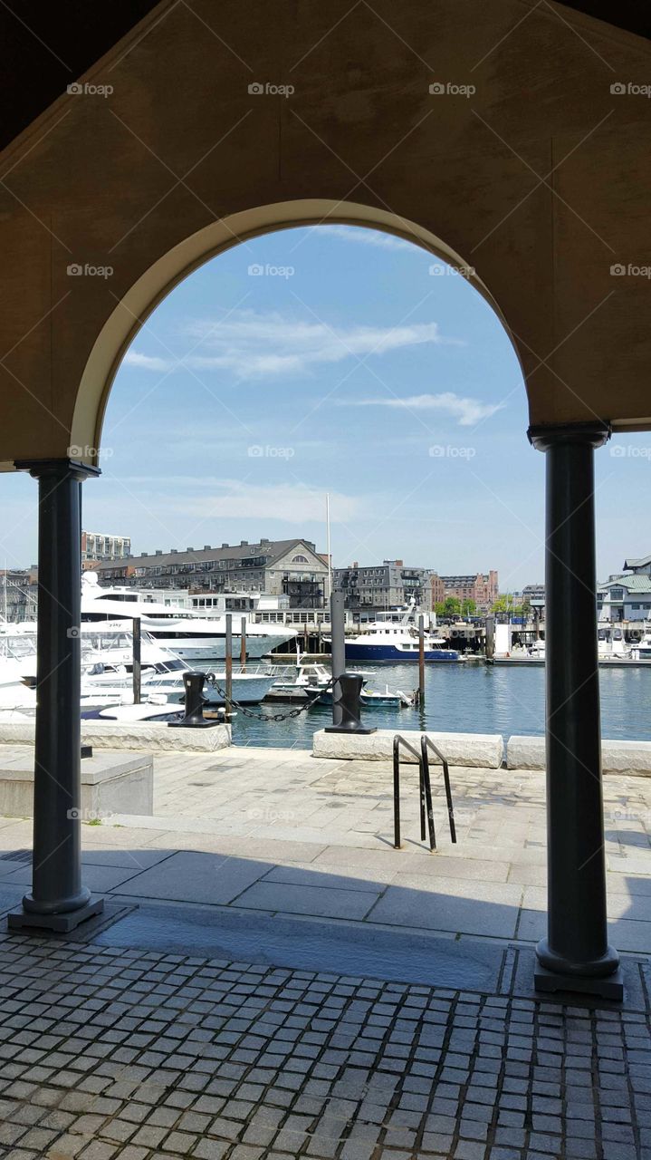 A view through arches looks upon a waterfront