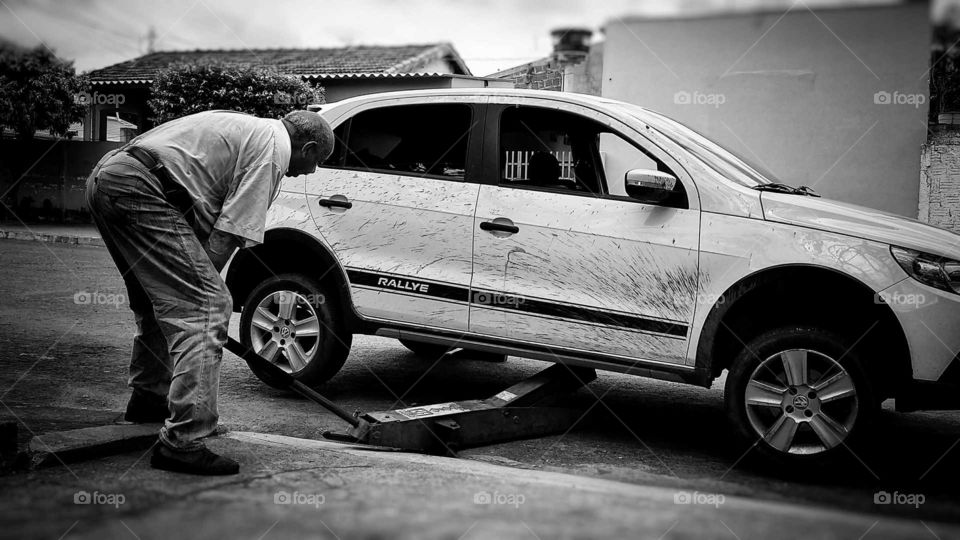 Manutenção de veículo em borracharia, homem trabalhando.