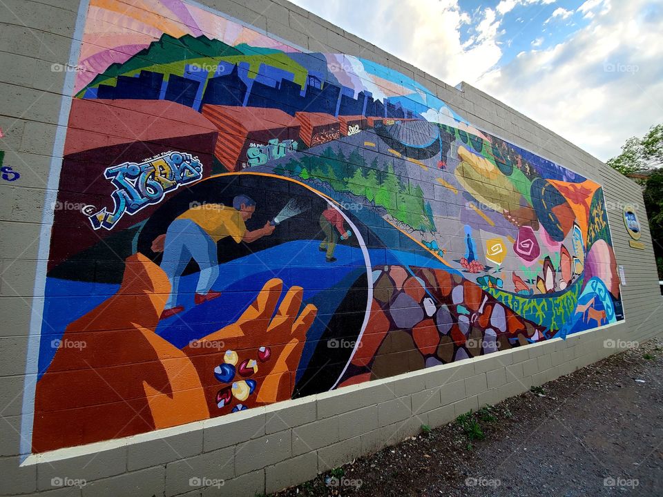 A colorful mural brightens a alleyway and presents an important story