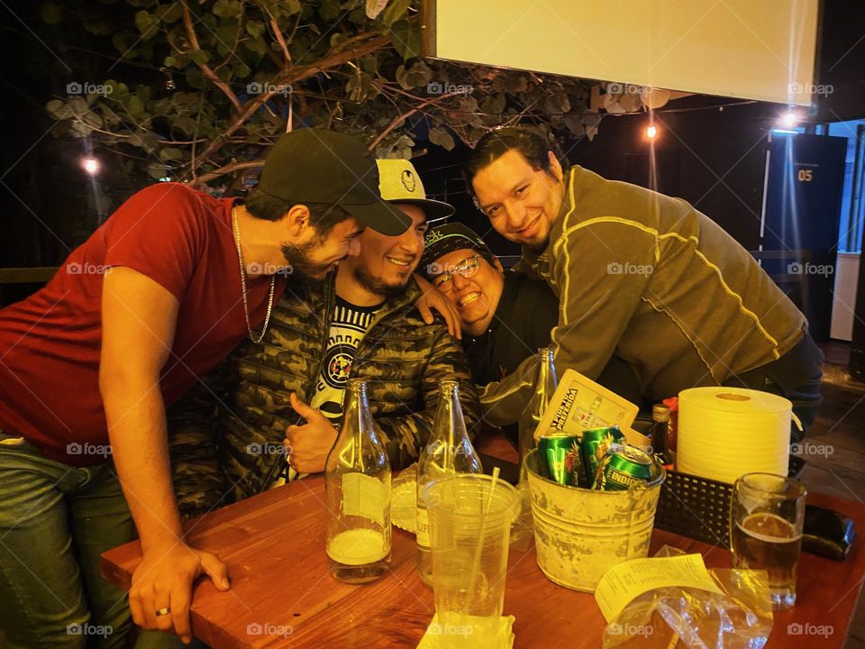 Group of man having a great night, laughing and enjoying in a bar during the night.