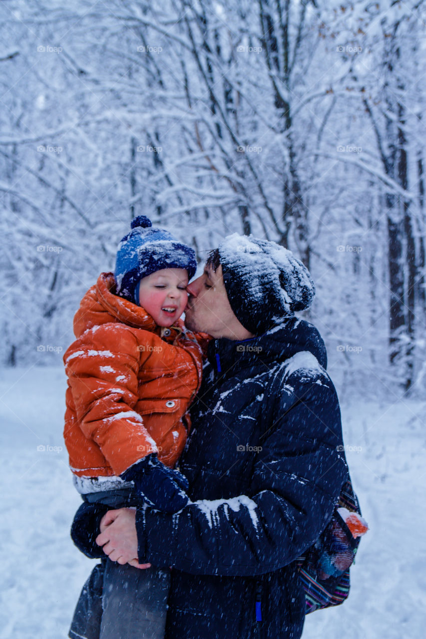 Father kissed son in the winter forest