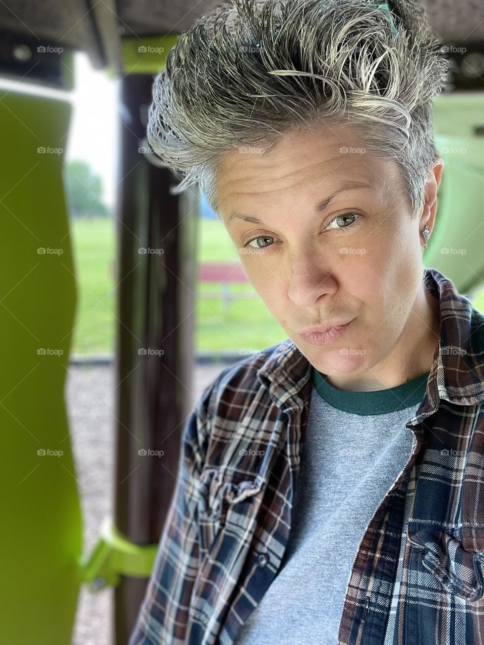 Woman under the slides at a park, woman posing for portrait at the park, sexy woman portrait, LGBTQ woman portrait, gazing at the lens, focused on the eyes, woman enjoys the outdoors