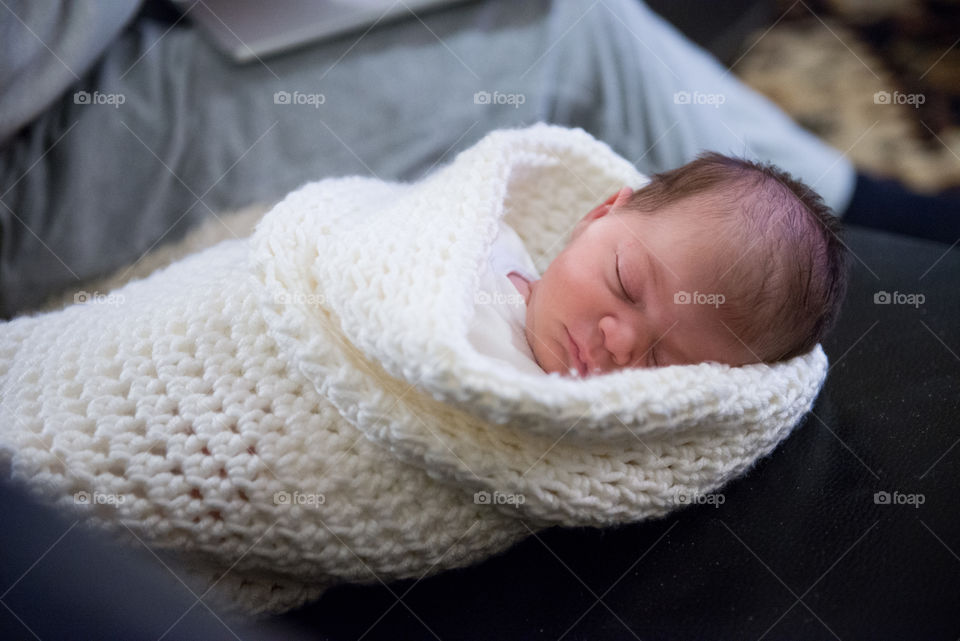 newborn sleeping in a crochet cocoon