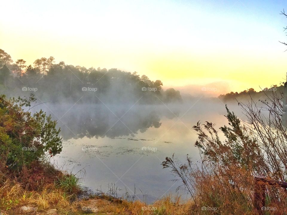 Morning fog on the lake during sunrise