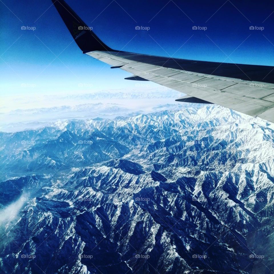 Пейзаж из самолета с видом на снежные горы 