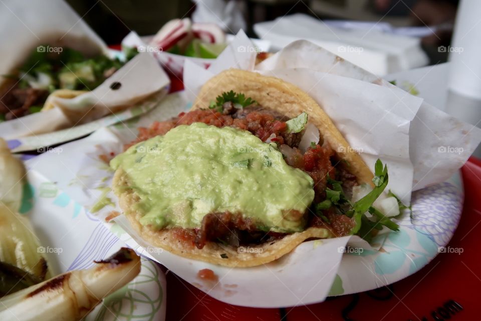 Salsa and guacamole on a taco.