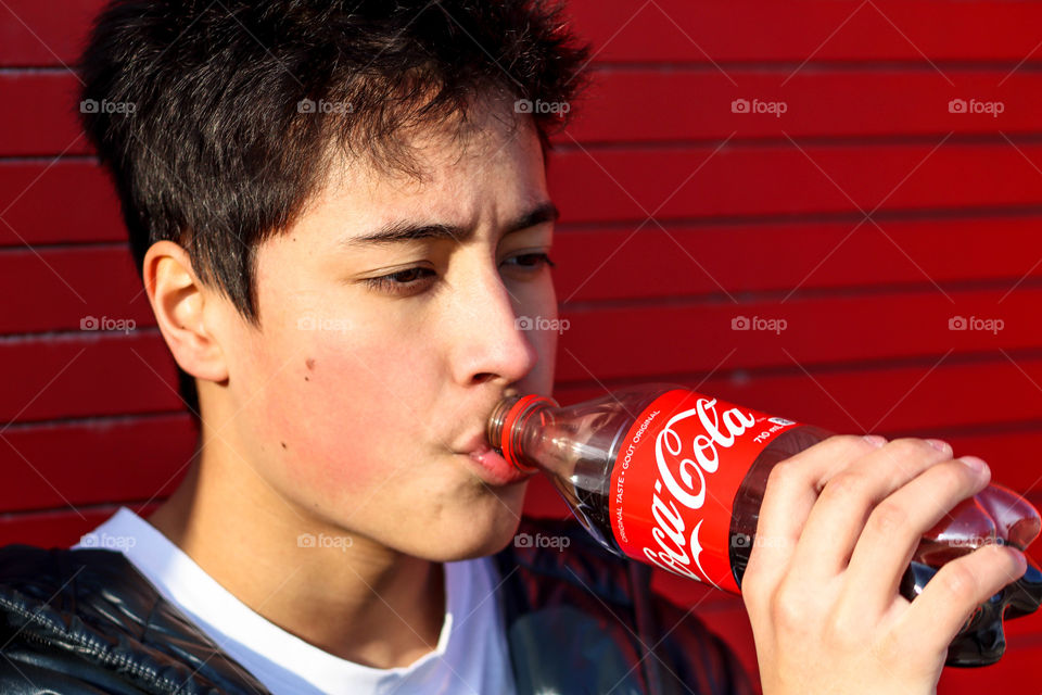 Young handsome man with a bottle of Coca-Cola