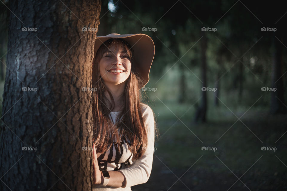 Portrait of Young woman in hat at evening park 