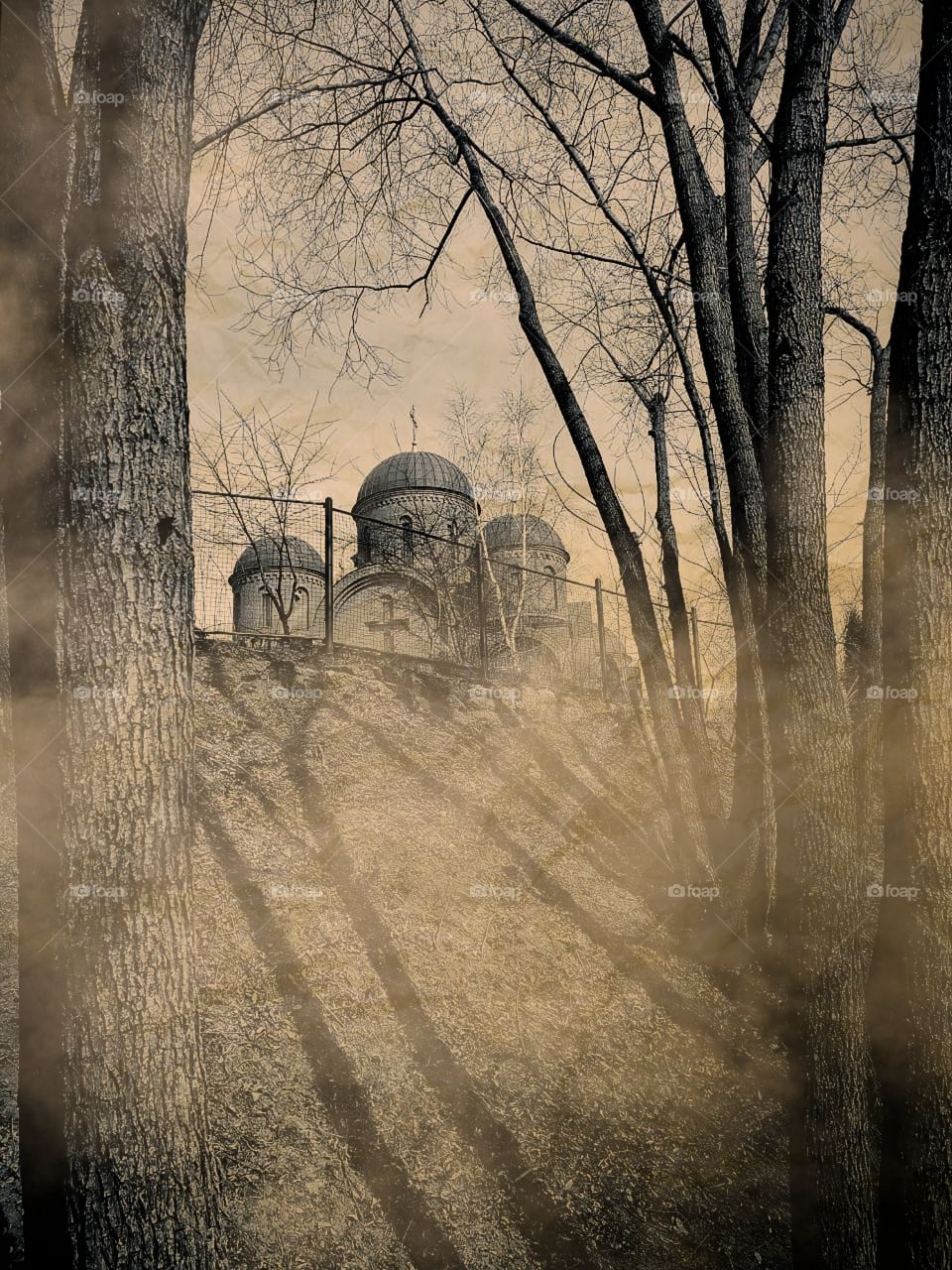 Small church on the hill.  Mist covers the hill and the shadows from the trees