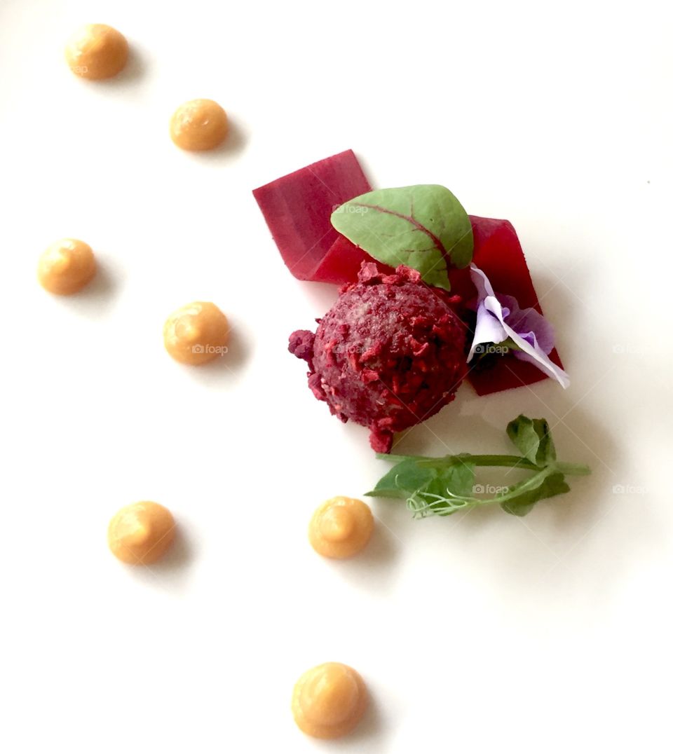 Beetroot sherbet with mango sauce and leafs