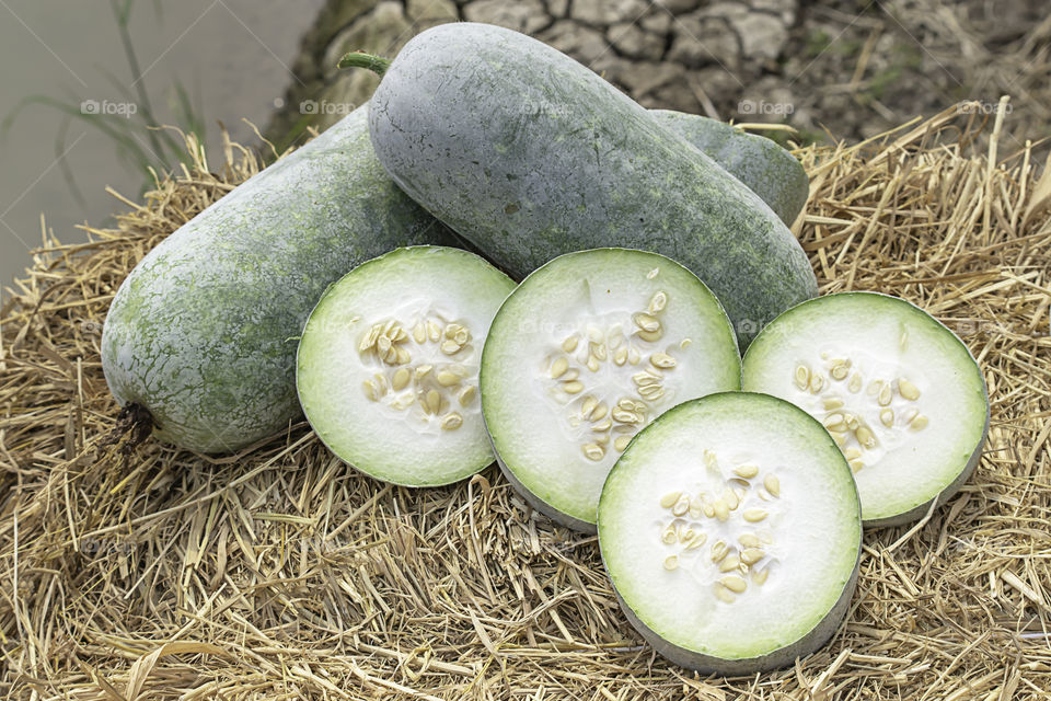 Winter melon is cut into pieces on the straw.