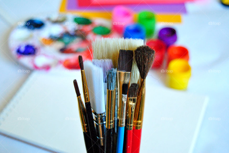 Art supplies, paintbrushes, paint, sketch book, watercolor pad, palette, paintbrush close-up