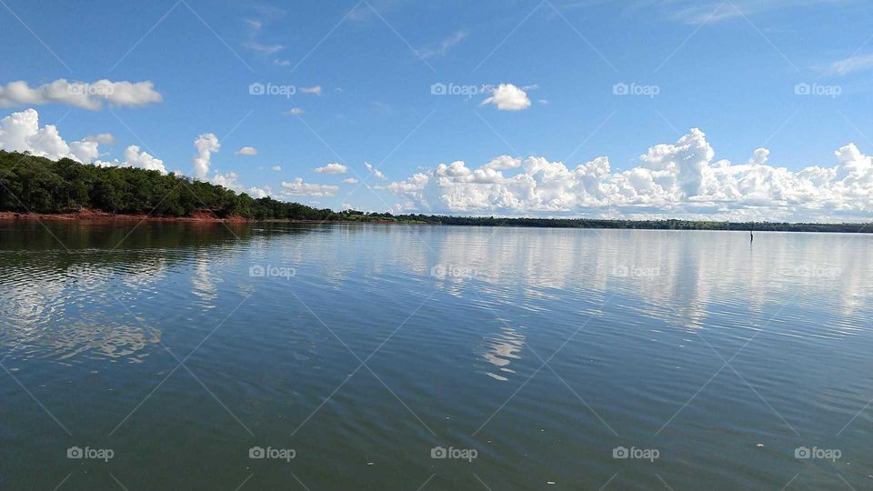 Uma paisagem de águas com o céu azul nublado.