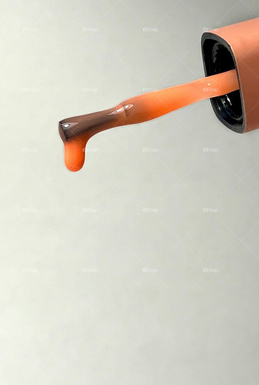 A drop on a brush of terracotta colored nail polish