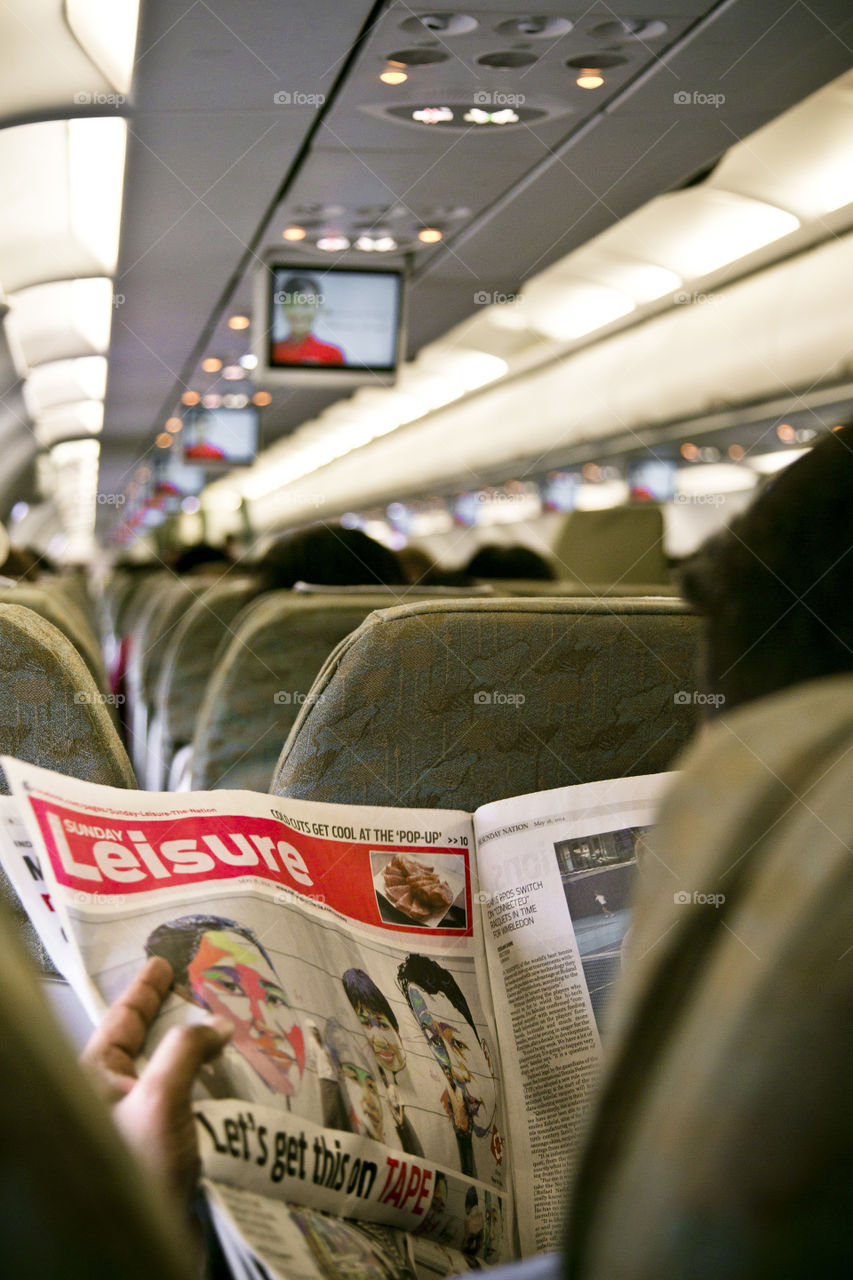 Seat back, relax and enjoy the flight. passenger reading during flight