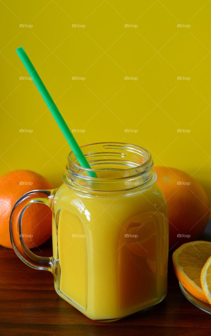 citrus fruits and orange juice in glass yellow background healthy food