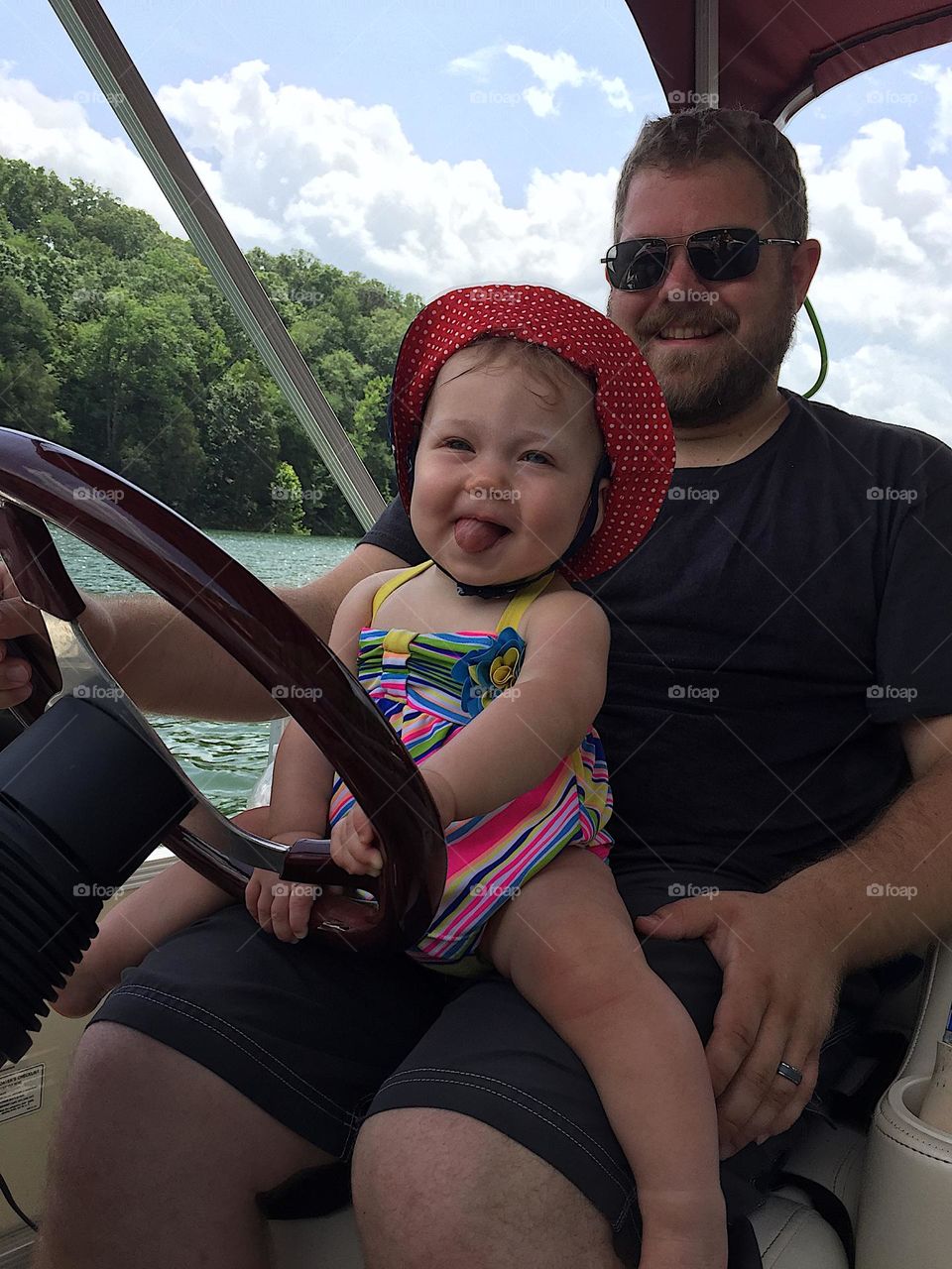 A dad and daughter driving the boat