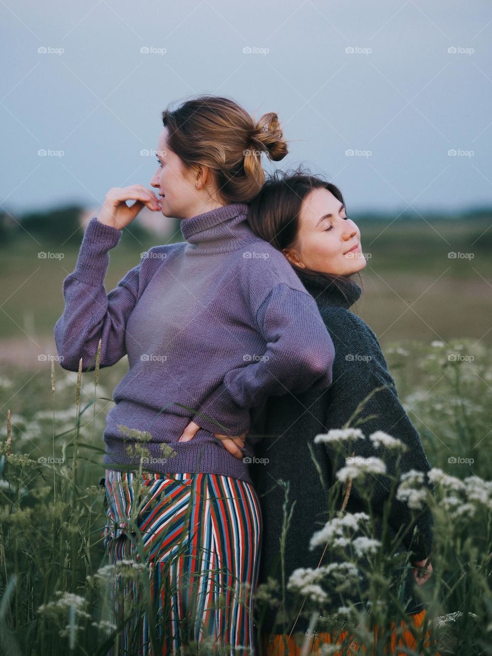 Beautiful girlfriends in the blooming field 