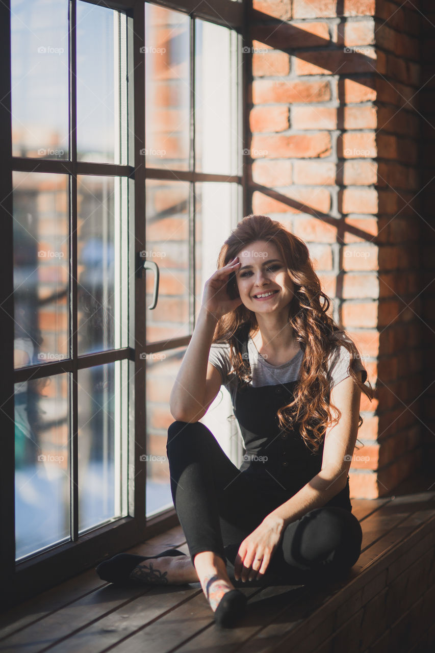 Portrait of young beautiful woman near window