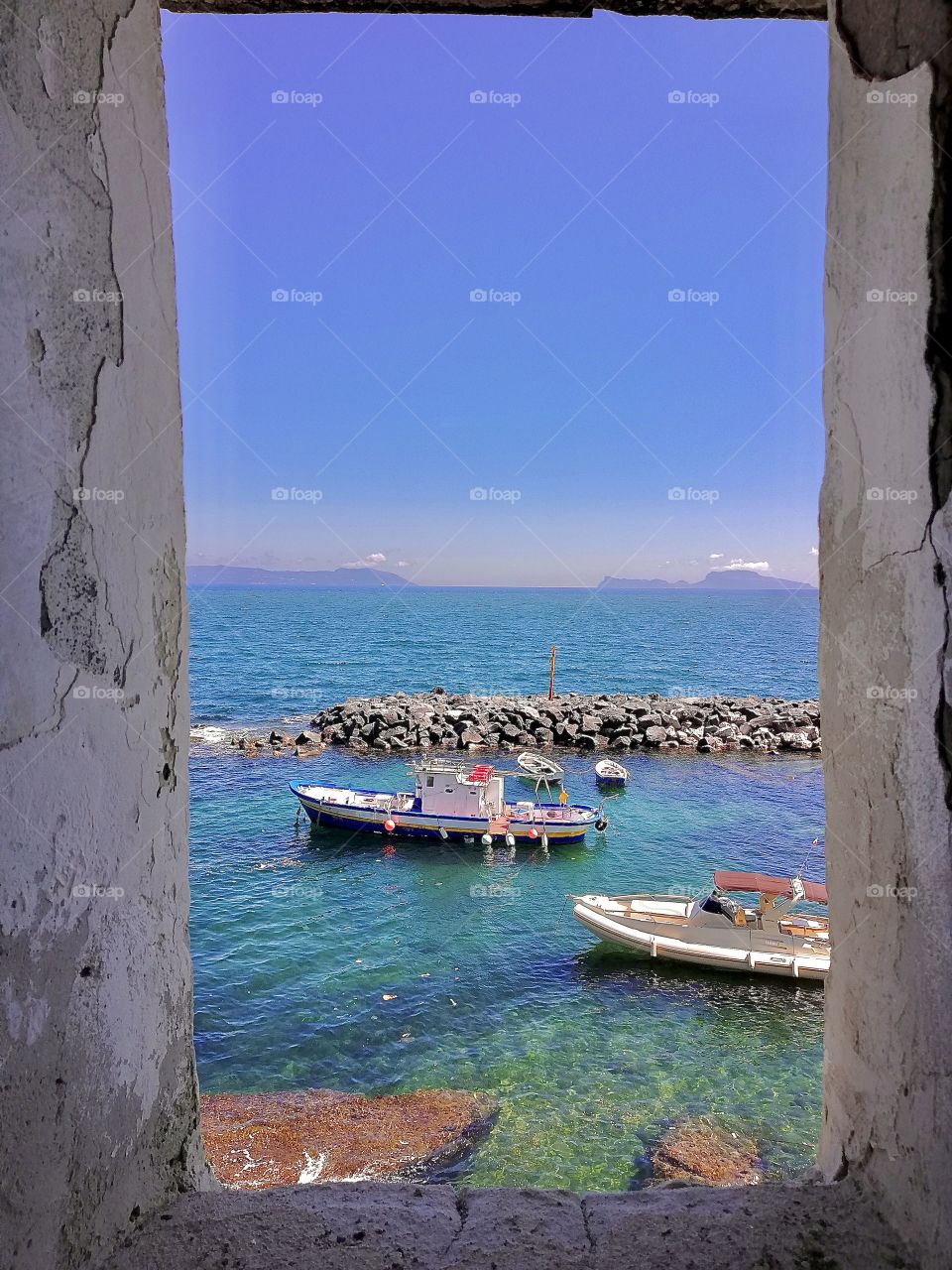 Looking the horizon sea from a window in the wall 