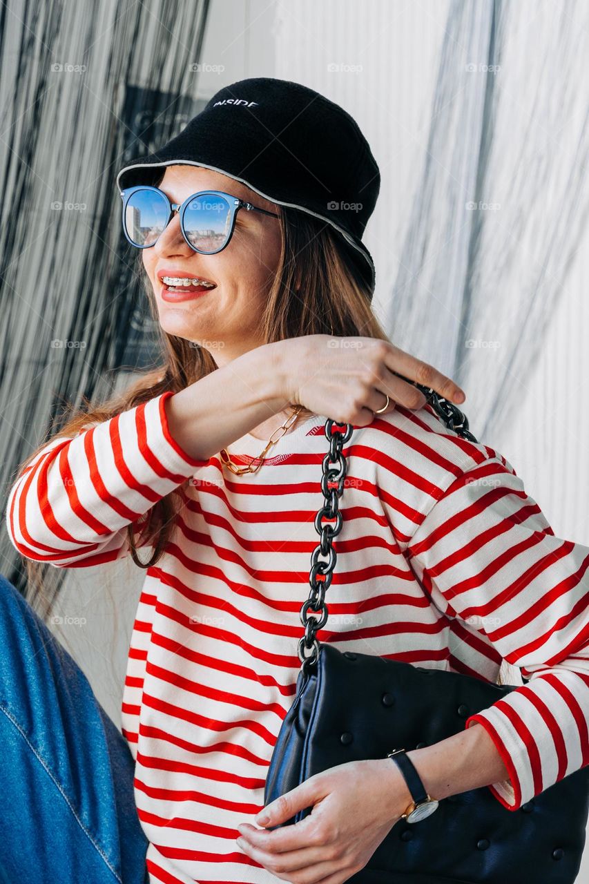 Stylish woman wearing hat, sunglasses, silver jewelry, rings, bracelets. Trendy accessories 