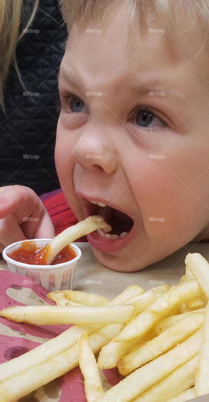 Boy eating French fries 