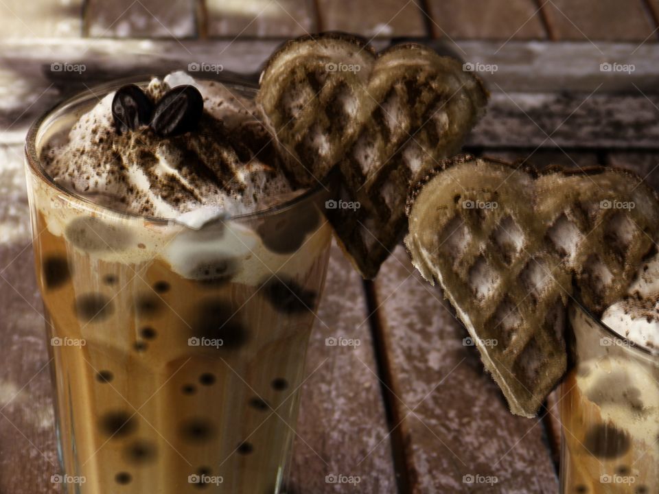 chocolate lumpy drink with cream topping served with chocolate lover hearts biscuits
